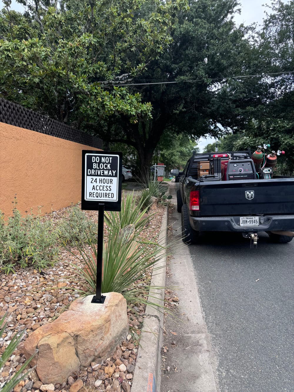 Sign advising to keep driveway clear for 24-hour access, parked truck nearby.